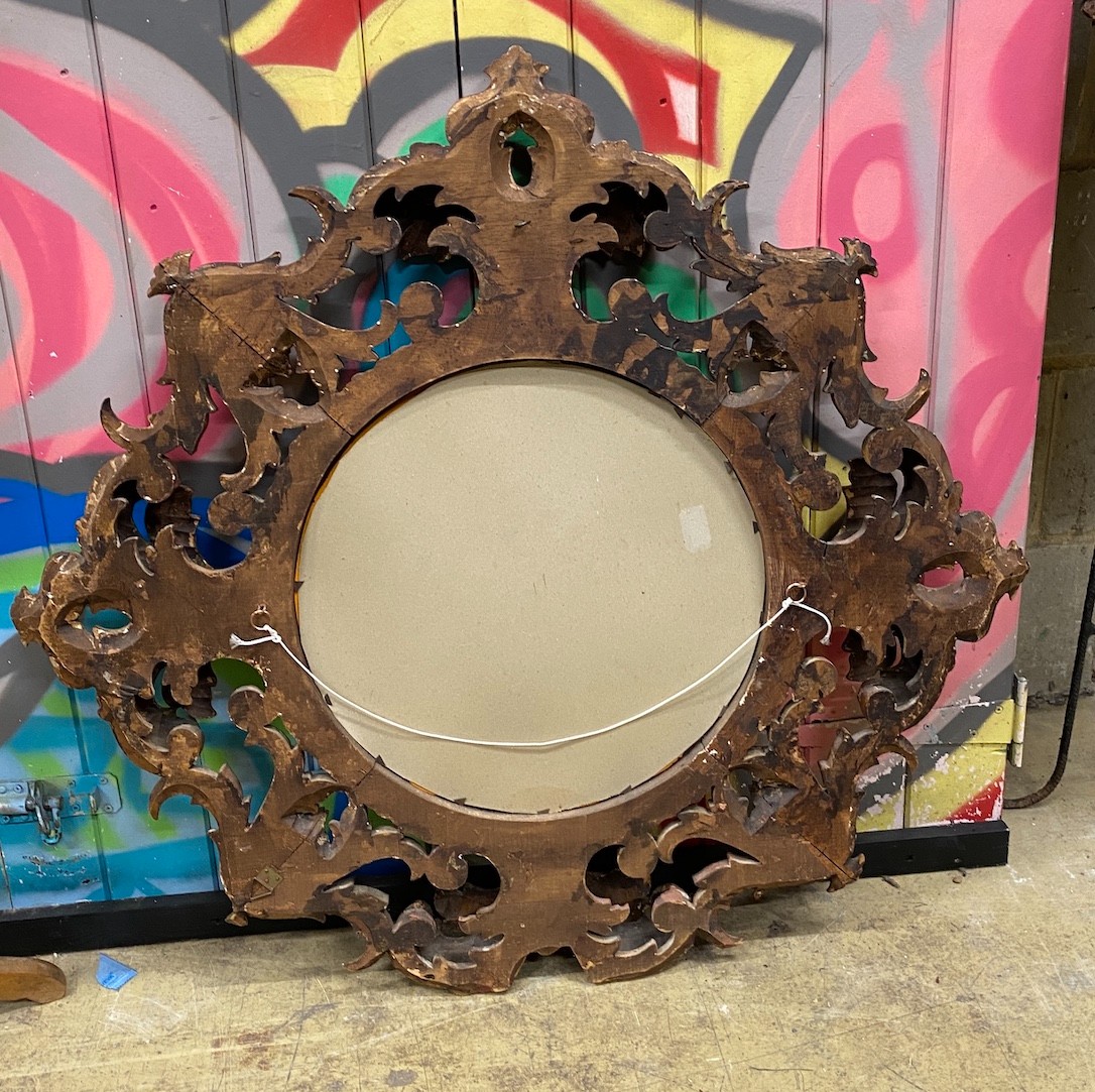 A circular wall mirror with carved giltwood frame, diameter 88cm